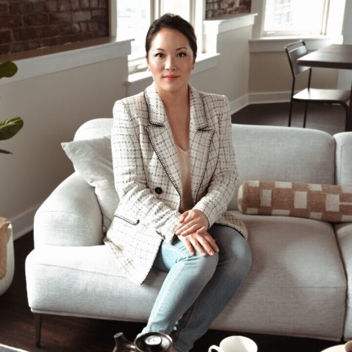 A woman sitting on top of a white couch.